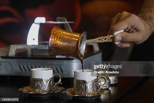 Manuel Cuerno, a specialist in preparing Turkish coffee, transfers coffee from an "Ibrik" or "Cezve" jug to a cups or "Fincam" during a sample...