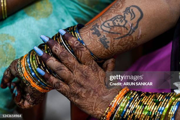 An expecting woman sports a tattoo of a mother and child as she takes part in a community baby shower ceremony organised by the social welfare...