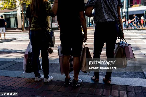 Shoppers carry bags in San Francisco, California, US, on Thursday, Sept. 29, 2022. US consumer confidence rose for a second month in September to the...