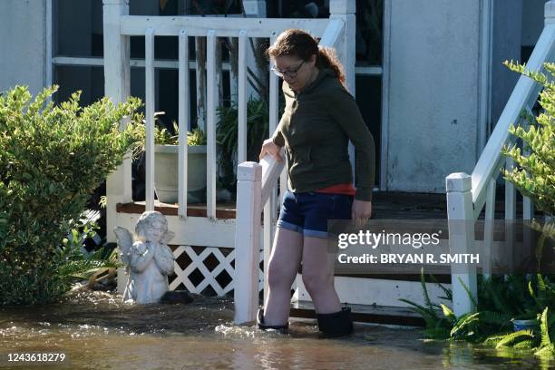 Woman walks down the stairs from her house as a creek overflows from flooding following Hurricane Ian on September 30, 2022 in Kissimmee, Florida. -...