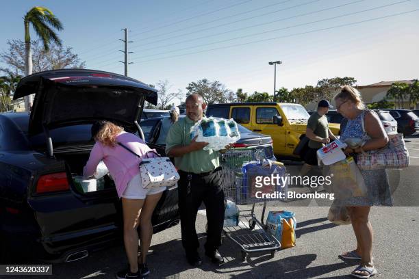 Customers load groceries into a car outside a Publix grocery store following Hurricane Ian in Cape Coral, Florida, US, on Friday, Sept. 30, 2022. Two...