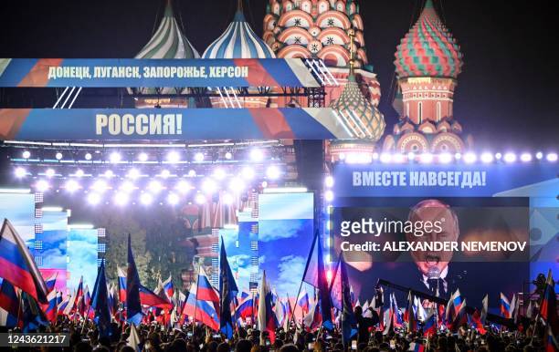 Russian President Vladimir Putin is seen on a screen set at Red Square as he addresses a rally and a concert marking the annexation of four regions...