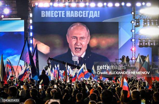 Russian President Vladimir Putin is seen on a screen set at Red Square as he addresses a rally and a concert marking the annexation of four regions...