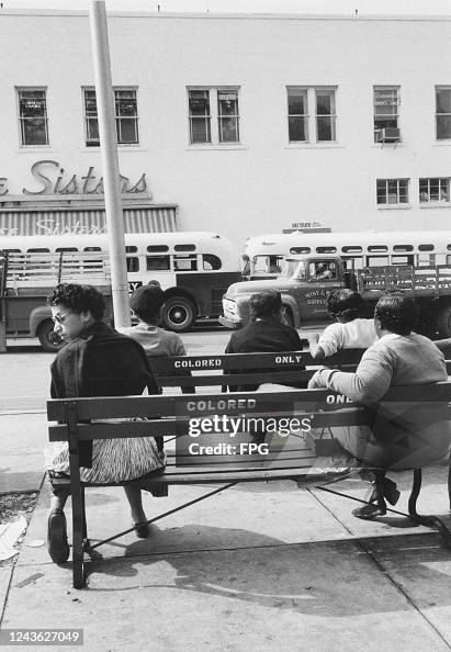 Five African American women sitting on a bench labelled 'Colored ...