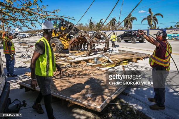 Florida Department of Transportation workers clear debris in Fort Myers Beach in the aftermath of Hurricane Ian on September 30, 2022. - Forecasters...
