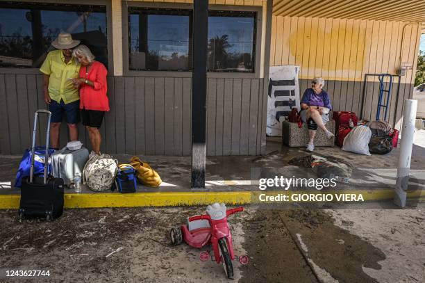 Residents of Fort Myers Beach rest at a gas station with some of their belongings in the aftermath of Hurricane Ian in Fort Myers Beach, Florida on...