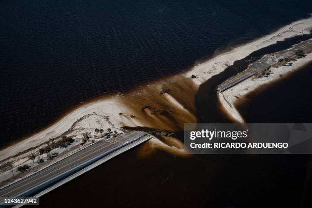 An aerial picture taken on September 30, 2022 shows the collapsed Sanibel Causeway in the aftermath of Hurricane Ian in Sanibel, Florida -...