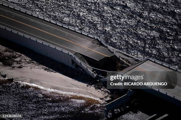 An aerial picture taken on September 30, 2022 shows the collapsed Sanibel Causeway in the aftermath of Hurricane Ian in Sanibel, Florida -...