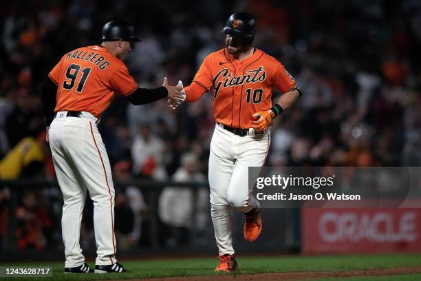 Evan Longoria of the San Francisco Giants is congratulated by Mark Hallberg after hitting a three run home run against the Arizona Diamondbacks...