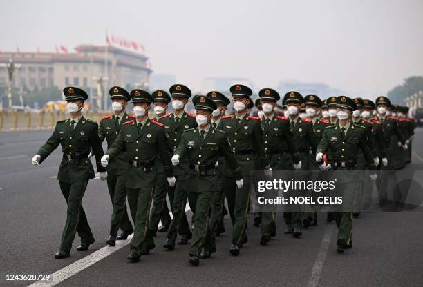 Soldiers march on Tiananmen Square after the flag-raising ceremony on China's National Day in Beijing on October 1, 2022.