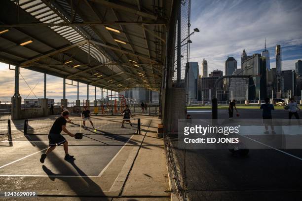 People play pickleball at a public court in Brooklyn, New York on September 16, 2022. - A game that's easy to pick up and more accessible than...