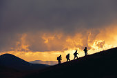 Group of hikers walks at majestic sunset in mountains