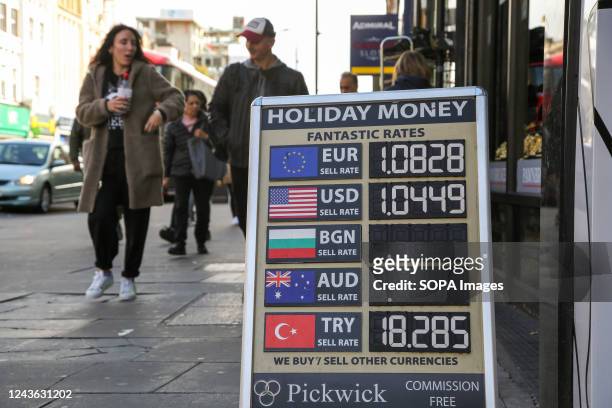 Currency exchange rates are displayed on a board outside a money exchange bureau.