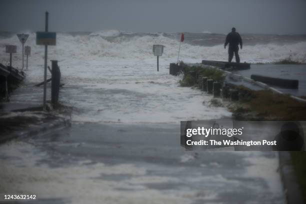 Man stands in front of storm surges in Myrtle Beach, SC on Sept. 30, 2022.