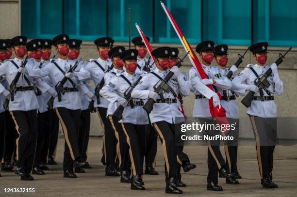 Police officers holding the National Flag of China and the HKSAR flag marching during the flag raising ceremony at Golden Bauhinia Square on October...