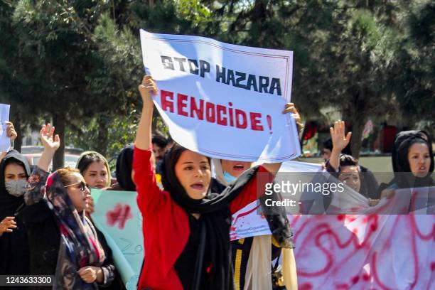 Afghan women display placards and chant slogans during a protest they call Stop Hazara genocide a day after a suicide bomb attack at Dasht-e-Barchi...