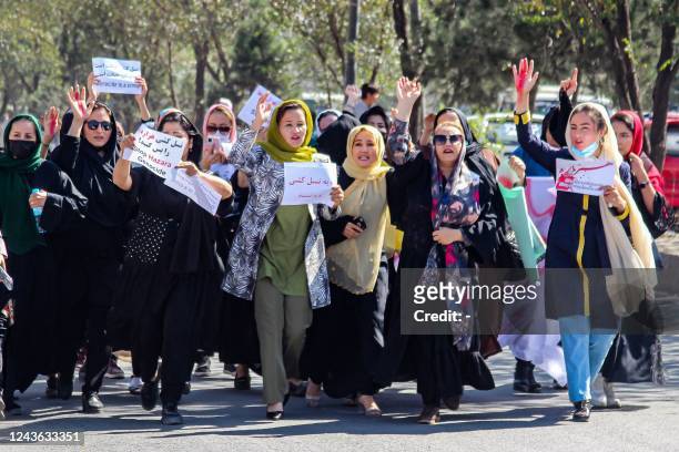 Afghan women display placards and chant slogans during a protest they call Stop Hazara genocide a day after a suicide bomb attack at Dasht-e-Barchi...