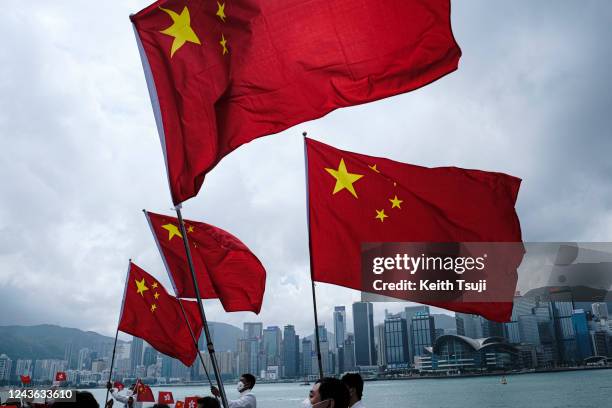 People wave with a flag of China to celebrate China National Day on October 1, 2022 in Hong Kong, China. China celebrates its National Day on October...
