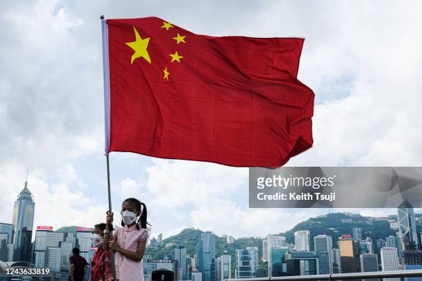 Little girl carries a flag of China to celebrate China National Day on October 1, 2022 in Hong Kong, China. China celebrates its National Day on...