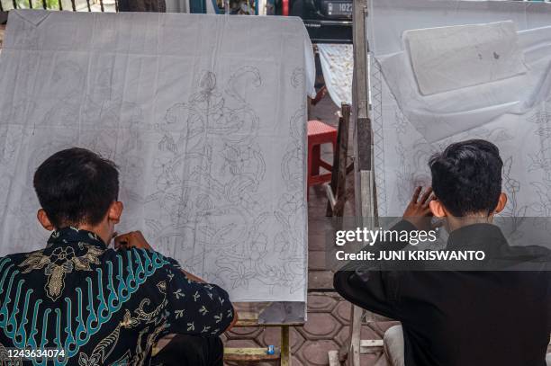 Batik makers draw on fabric before they apply hot wax to produce the traditional Indonesian textile, made using wax-resist dyeing methods, in...
