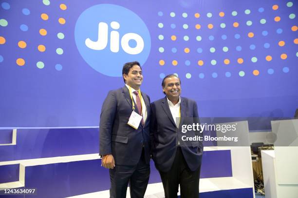 Mukesh Ambani, chairman of Reliance Industries Ltd., right, with his son Akash Ambani, chairman of Reliance Jio Infocomm Ltd., visit a company's...