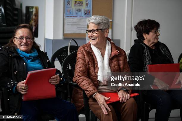 Woman smiles as she chats to other people ahead of a choir class at the socio-recreational center âLa porta del cuoreâ in the Gallaratese quarter in...