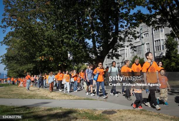 People wearing orange T-shirts attend an event to commemorate the National Day for Truth and Reconciliation at University of British Columbia in...