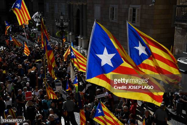 People holding Catalan pro-independence Estelada flags gather at Plaza Sant Jaume in Barcelona on October 1, 2022 to take part in a demonstration...