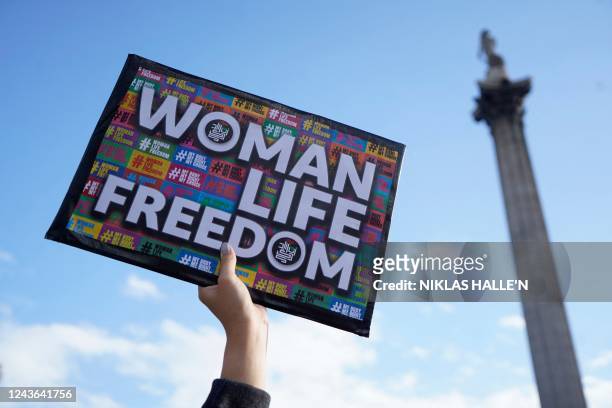 Protester holds up the 'Woman Life Freedom' slogan on a placard as people gather in support of Kurdish woman Mahsa Amini during a protest on October...