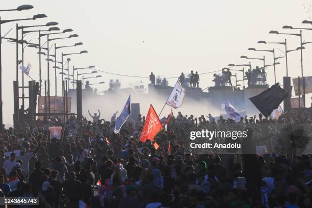 Hundreds of Iraqis hold banners and shout slogans as they gather during a demonstration marking the third anniversary of the eruption of nationwide...