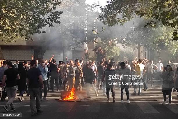 Iranian protesters march down a street on October 1, 2022 in Tehran, Iran. Protests over the death of 22-year-old Iranian Mahsa Amini have continued...