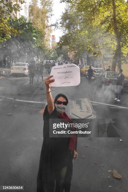 Protester holds up a note reading "Woman, Life, Freedom, #MahsaAmini" while marching down a street on October 1, 2022 in Tehran, Iran. Protests over...