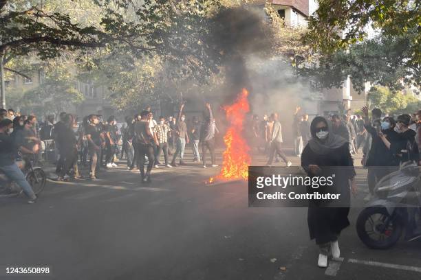Iranian protesters march down a street on October 1, 2022 in Tehran, Iran. Protests over the death of 22-year-old Iranian Mahsa Amini have continued...