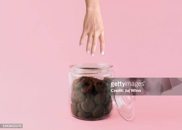 hand reaching into cookie jar - cookie jar stock-fotos und bilder