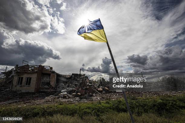 Ukrainian flag waves in a residential area heavily damaged in the village of Dolyna in Donetsk Oblast, Ukraine after the withdrawal of Russian troops...
