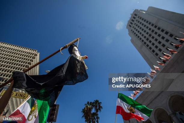 Woman holds a dummy doll representing Iran's Supreme Leader Ali Khamenei in a noose during a protest for Mahsa Amini who died in custody of Iran's...