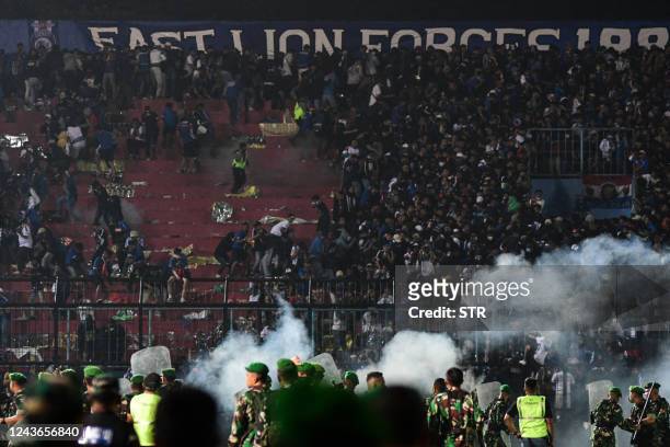 This picture taken on October 1, 2022 shows security personnel on the pitch after a football match between Arema FC and Persebaya Surabaya at...