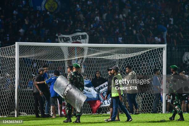 This picture taken on October 1, 2022 shows Indonesian army and police securing the pitch after a football match between Arema FC and Persebaya...