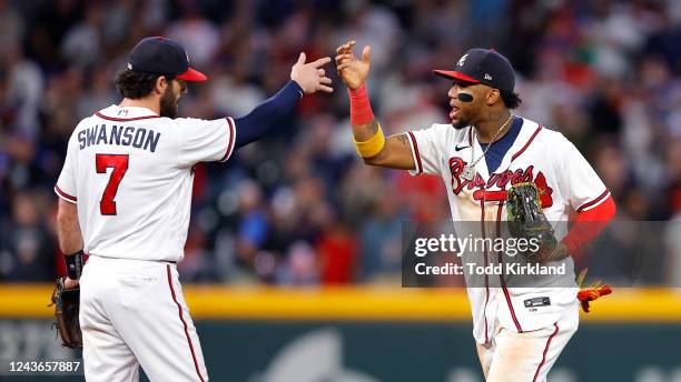 Dansby Swanson and Ronald Acuna Jr. #13 of the Atlanta Braves celebrate the 4-2 victory over the New York Mets at Truist Park on October 1, 2022 in...