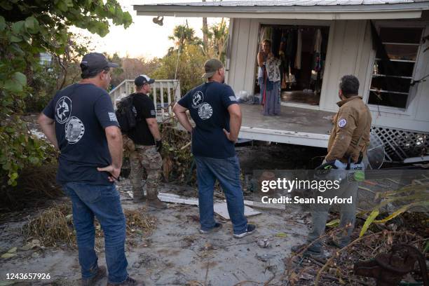 Members of the Project DYNAMO rescue organization talk with a resident in a storm damaged home in the wake of Hurricane Ian on October 1, 2022 on...