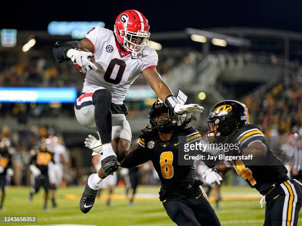 Darnell Washington of the Georgia Bulldogs leaps while running the ball against Ty'Ron Hopper and Kris Abrams-Draine of the Missouri Tigers during...