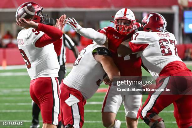 Connor Bazelak of the Indiana Hoosiers gets a pass ahead of the outreached hand of Garrett Nelson of the Nebraska Cornhuskers in the fourth quarter...