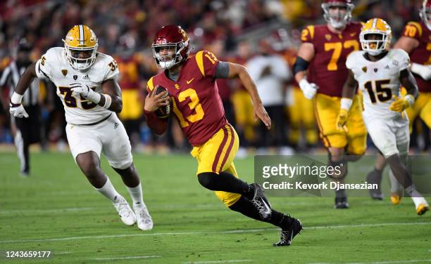 Quarterback Caleb Williams of the USC Trojans rushes out of the pocket and gains a first down B.J. Green II of the Arizona State Sun Devils during...