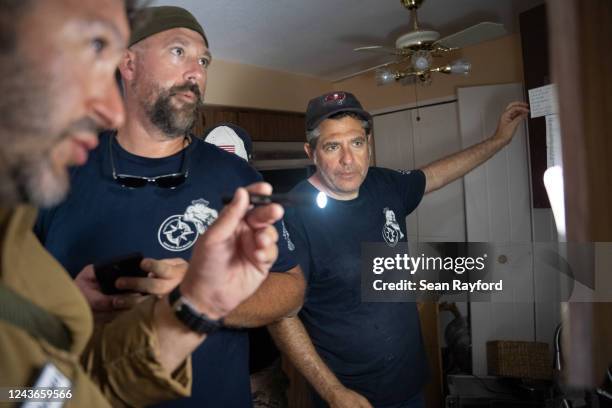 Dean Calderone, right, James Judge and Ryan Stern, founder of the Project DYNAMO rescue organization look for information to confirm the residence of...