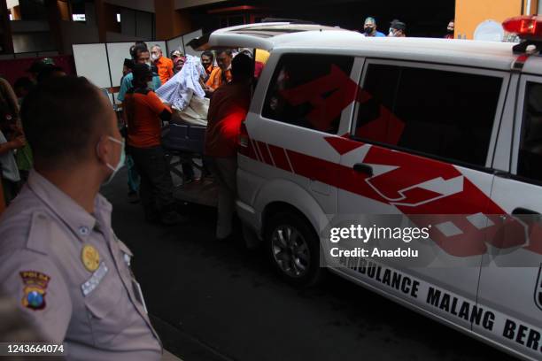 Officers using an ambulance transport the bodies of victims of a football match riot at a public hospital, in Malang, East Java, on October 2, 2022....