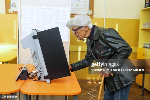 Voter casts her ballot at a polling station during the country's parliamentary elections in Sofia on October 2, 2022. - Bulgarians began voting in...