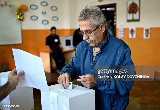 Voter casts his ballot at a polling station during the country's parliamentary elections in Sofia on October 2, 2022. - Bulgarians began voting in...