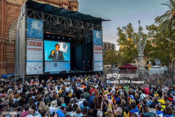 Former President Carles Puigdemont is seen on the screen from exile addressing the demonstrators. Thousands of people have participated in the...
