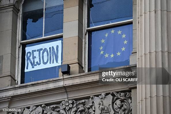 A rejoin the EU sign is seen in a window as anti-government protests ...