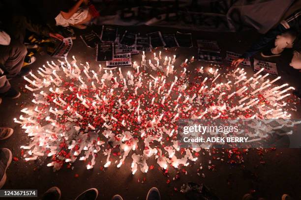 Candles, banners and flower petals are pictured during a candlelight vigil by Indonesian football supporters to show their condolences to victims of...